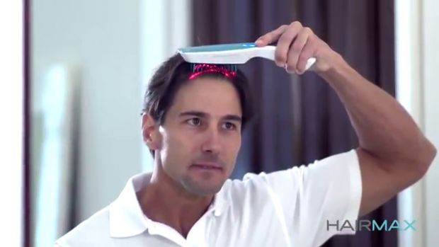 a man using the hairmax laser comb